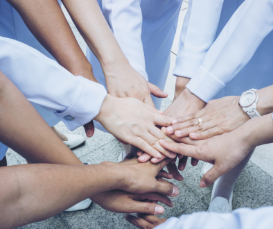 Nurses putting their hands together in a huddle