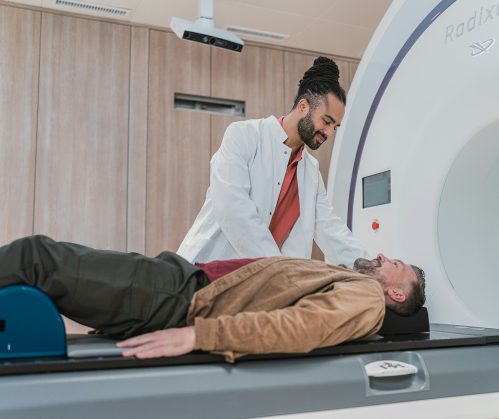 Radiology Technologist operating CT Scan with patient in place